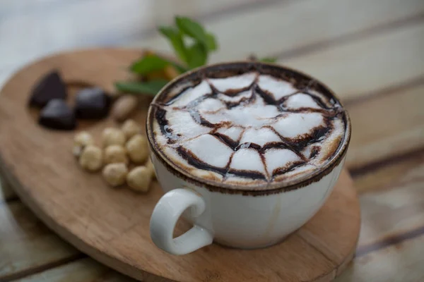 Fındıklar masada bir fincan kapuçinonun yanında.