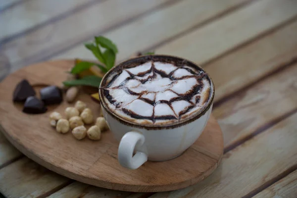 Fındıklar masada bir fincan kapuçinonun yanında.