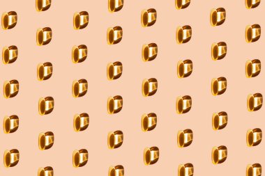 Sarı omega 3 kapsülünden yapılmış yaratıcı desen. Vitamin ve takviye konsepti. En az stil. Üst Manzara. Düz yatıyordu.