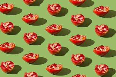 Yaratıcı desen, gölgeli yeşil arka planda yarım taze nar deseni. Yenileme konsepti. Sağlıklı besin içeriği teması.