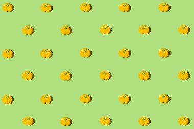 Creative pattern made of yellow bell pepper on green pastel background with shadows. Minimal style. Healthy food ingredient concept