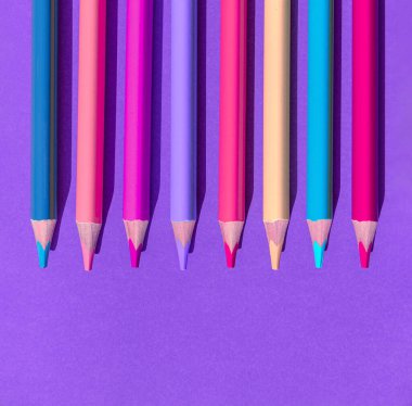 Set of colorful wooden pencils on violet background. Minimal style. Top view. Flat lay. Back to school concept.