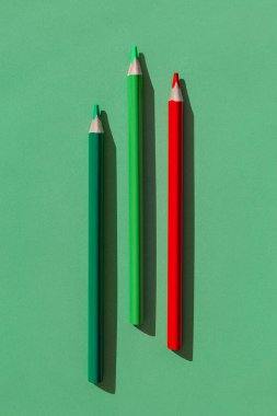 Colorful wooden pencils on green background. Minimal style composition. Top view. Flat lay. Back to school concept
