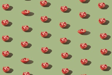 Yaratıcı desen, gölgeli yeşil arka planda yarım taze nar deseni. Yenileme konsepti. Sağlıklı besin içeriği teması.