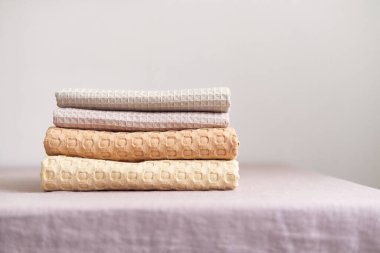 Doğal muslin mutfak havlularının toplanması düzgünce dikey yığılmış. Doğal, yumuşak, havadar ve şık mutfak tekstili..