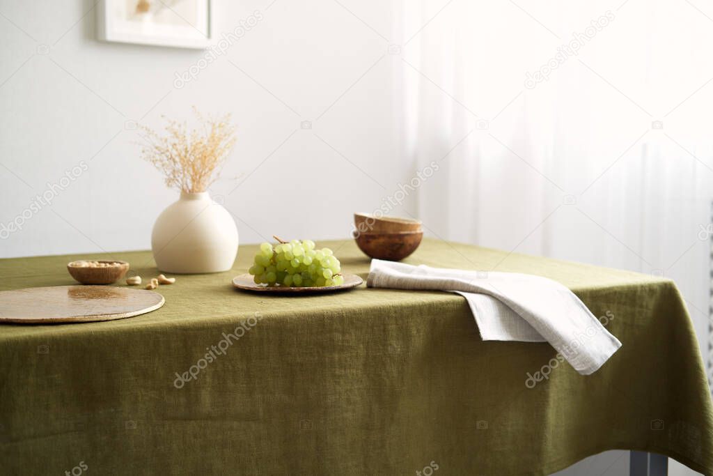 Modern dining table setting. Only natural materials - earthenware, linen textiles, dried flowers.