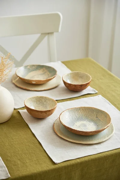 Moderní nastavení jídelního stolu. Pouze přírodní materiály - hliněné nádobí, lněné textilie, sušené květiny. — Stock fotografie