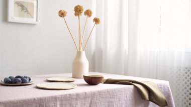 Modern yemek masası. Sadece doğal malzemeler - toprak eşyalar, keten kumaşlar, kurumuş çiçekler.