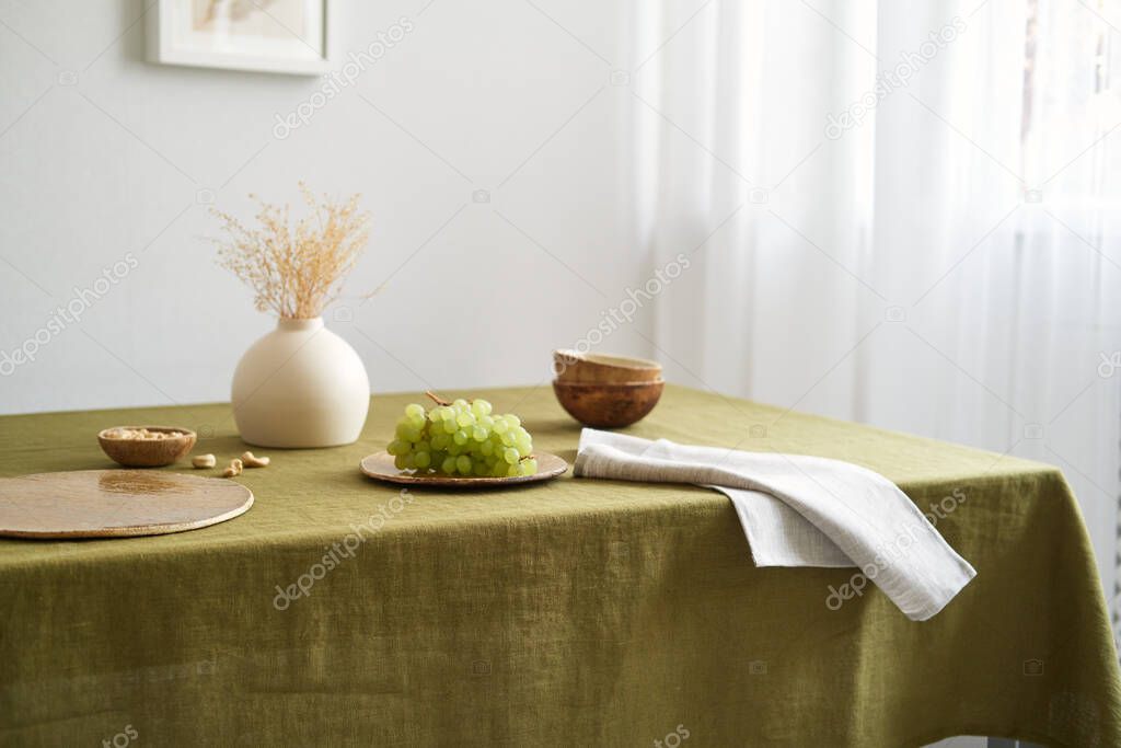 Modern dining table setting. Only natural materials - earthenware, linen textiles, dried flowers.