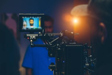 Yönetmen ve aktör kamera önünde sette.