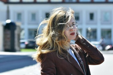 Saçları rüzgarda dalgalanan genç bir kızın portresi.