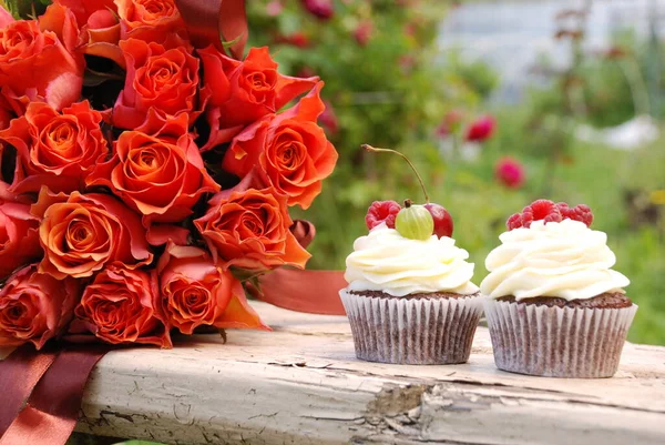 Yaz meyveli kekler ve bir buket gül.