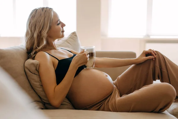 Zwangere Vrouw Met Een Kopje Koffie Zittend Bank Thuis — Stockfoto