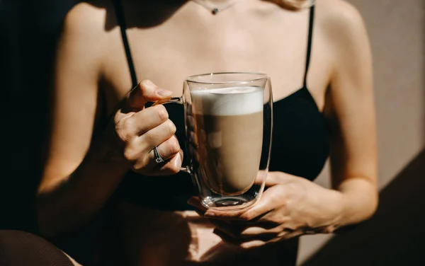 太陽の光の下でラテとコーヒーの透明なガラスカップを保持している女性の閉鎖 — ストック写真
