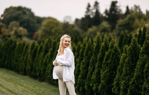 Ξανθιά Έγκυος Γυναίκα Περπατώντας Στο Πράσινο Γρασίδι Ένα Πάρκο Χαμογελώντας — Φωτογραφία Αρχείου