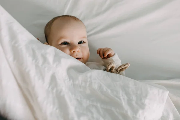 Primer Plano Bebé Feliz Acostado Cama Bajo Una Manta Blanca —  Fotos de Stock