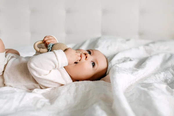 Πέντε Μηνών Μωρό Ξαπλωμένο Στο Κρεβάτι Παίζει Ένα Παιχνίδι Δαγκώνει — Φωτογραφία Αρχείου
