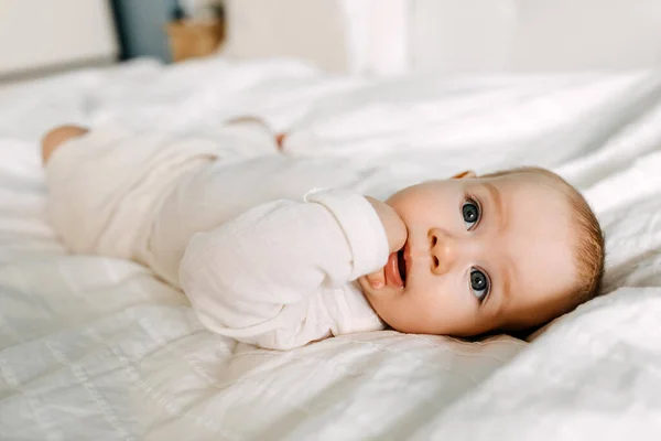Yatakta Uzanmış Parmaklarını Emen Kameraya Bakan Bir Bebeğin Yakın Çekimi — Stok fotoğraf