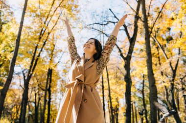 Genç bayan gülümsüyor, sıcak sonbahar havasının tadını çıkarıyor..