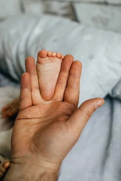 Ojciec Trzyma Małą Stopkę Ręku Zbliżenie — Zdjęcie stockowe