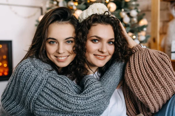 Дві Щасливі Молоді Жінки Фоні Ялинки Обіймаються Посміхаються Дивляться Камеру — стокове фото