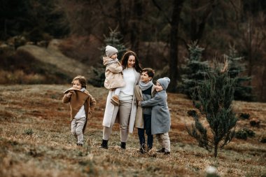 Birçok çocuklu anne, bir sonbahar gününde çocuklarla parkta vakit geçiriyor..