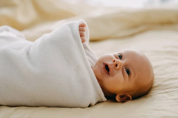 Новонароджена Дитина Загорнута Ковдру Лежить Ліжку Посміхаючись — стокове фото