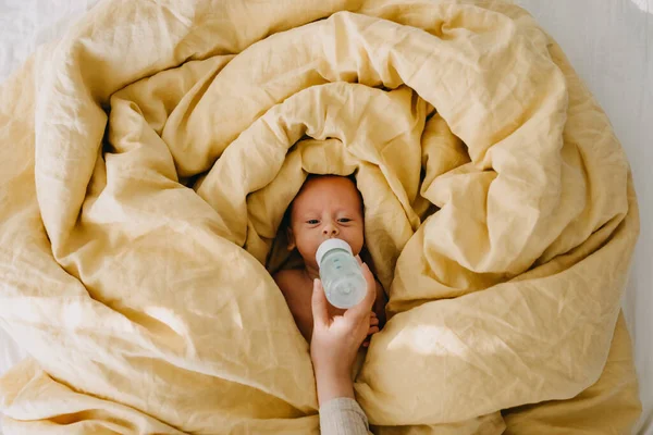 Mother Bottle Feeding Newborn Baby Lying Bed Covered Big Yellow — Stock Photo, Image