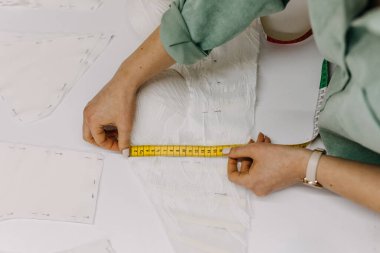 Moda tasarımcısı çalışma süreci, yeni elbise için model ölçümleri. Stüdyoda terzi.. 