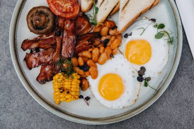 Bir İngiliz kahvaltısının kapanışı. Pastırmalı yumurta, fasulye, mısır ve sebze..