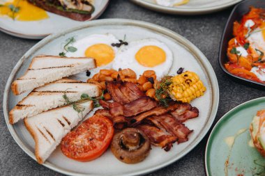Bir İngiliz kahvaltısının kapanışı. Pastırmalı yumurta, fasulye, mısır ve sebze..