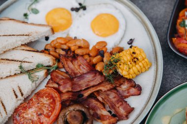 Bir İngiliz kahvaltısının kapanışı. Pastırmalı yumurta, fasulye, mısır ve sebze..