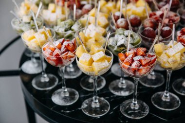 Bir parti resepsiyonunda bardakta çeşitli taze meyve ve meyveler. Sağlıklı tatlı konsepti.