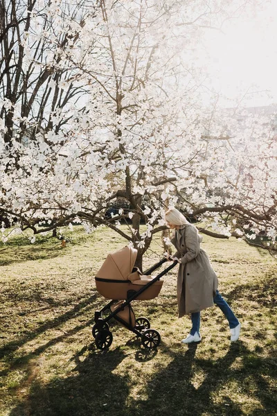 Blonde Woman Walking Stroller Park Springtime Magnolia Tree Bloom — стоковое фото