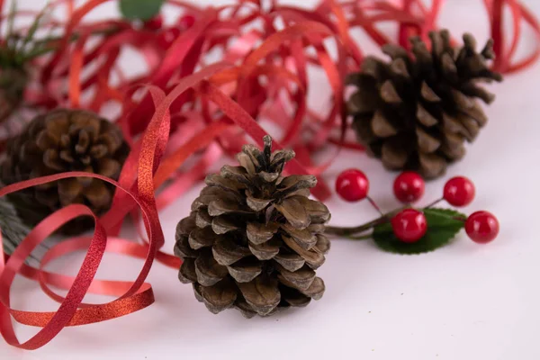 Ornamento Natal Fundo Branco Bagas Vermelhas Cone Pinho Fita Vermelha — Fotografia de Stock