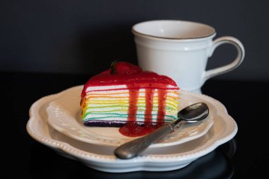 Siyah arka planda bir fincan kahveli krep.