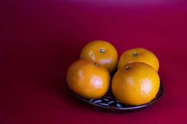 Fresh Oranges with Tiny Chinese Red Lantern on Red Background