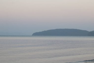 Gün doğmadan önce doğanın saflığı, ince kumda dalgalanan yumuşak deniz dalgaları.