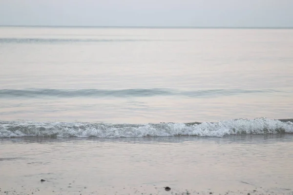 太陽が沈む前のビーチの風景は 静かで穏やかな 波が風の強い風と細かい砂をそっと打つ — ストック写真