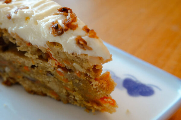 a slice of delicious carrot cake topped with ultra-creamy cream cheese frosting