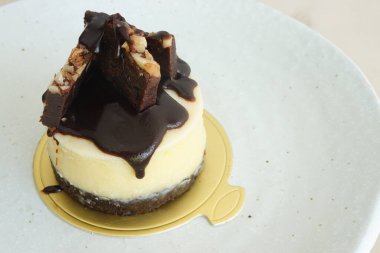 Tatlı tatlı, mini brownie peynirli kek, sıcak kahve ya da sıcak çay ile servis edilir.