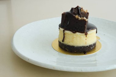 Tatlı tatlı, mini brownie peynirli kek, sıcak kahve ya da sıcak çay ile servis edilir.