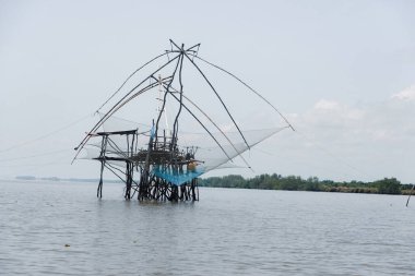 Güneşli bir günde mavi denizde ahşap bir yapı üzerine Dip Net Kare