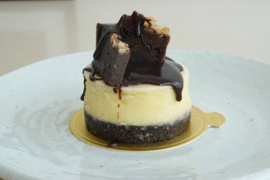 Tatlı tatlı, mini brownie peynirli kek, sıcak kahve ya da sıcak çay ile servis edilir.