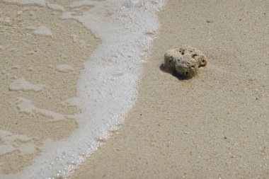 Deniz kenarındaki yaz tatilleri, sakin ve sakin. Özet olarak, arka plandaki güzel kumlar üzerinde açık deniz dalgaları.