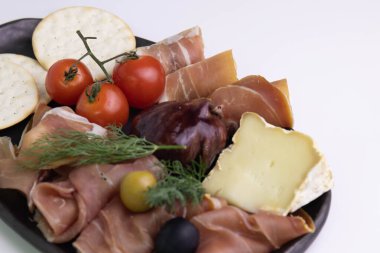 Foie Gras ile dolu Karamelize İncirleri kapatın. Soğuk Et Tabağı ve Peynir ile servis ediliyor.