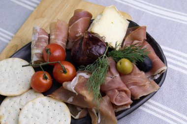 Foie Gras ile dolu Karamelize İncirleri kapatın. Soğuk Et Tabağı ve Peynir ile servis ediliyor.