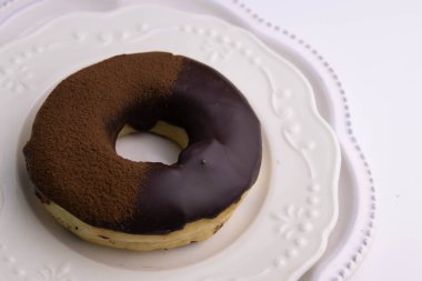 tasty deep fried Donut glazed with chocolate syrup and chocolate powder