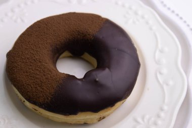 tasty deep fried Donut glazed with chocolate syrup and chocolate powder