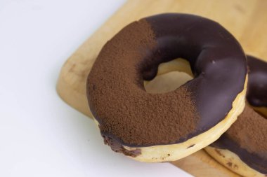 tasty deep fried Donut glazed with chocolate syrup and chocolate powder